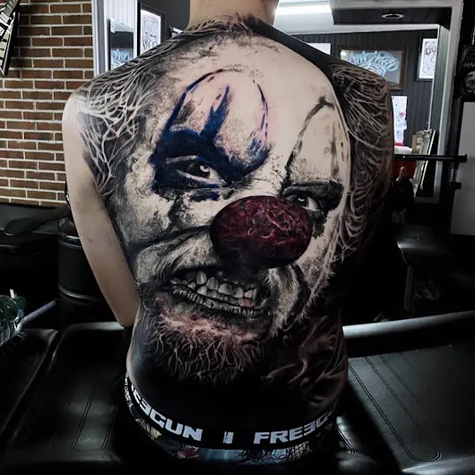 Grand portrait de clown tatoué sur l’ensemble du dos, par Flow.